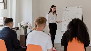wanita sedang presentasi mengenai performa bidang pendidikan