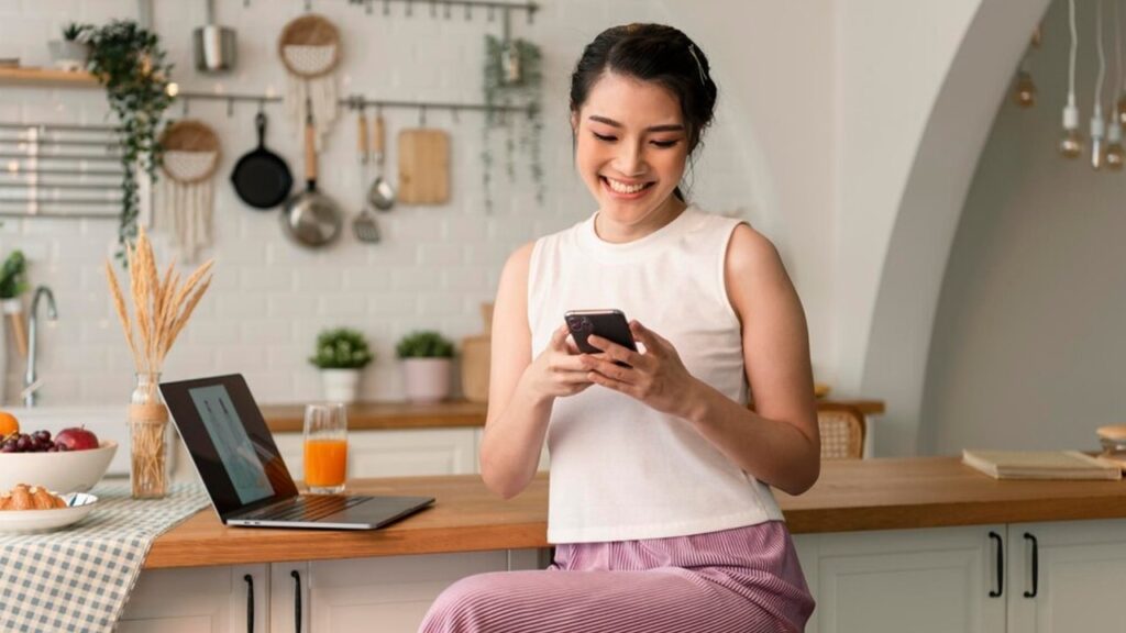 perempuan tersenyum sambil mengaktivasi digital marketing untuk lembaganya.